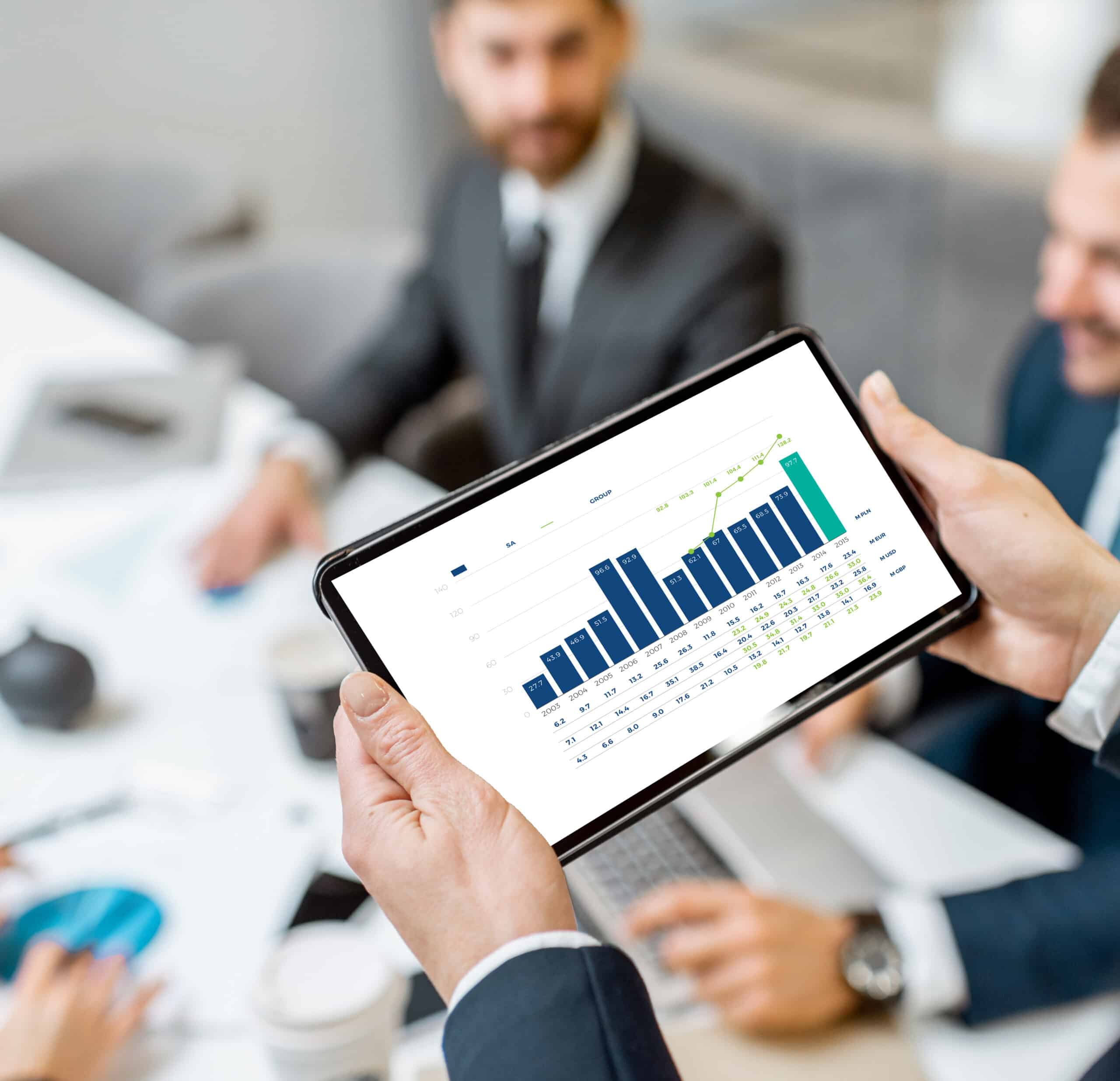 person holding a tablet with graphs being displayed on the screen